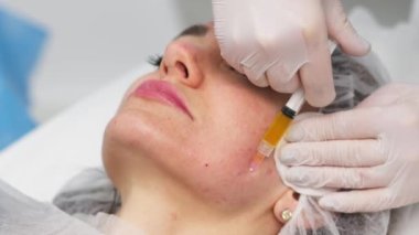 Modern kozmetik kliniğinde botulinyum terapisi yapan bir kadın. Profesyonel kozmetik uzmanı cilt tazelemek için botoks yapıyor. Çekici, sabırlı, pürüzsüz kırışıklıklar. Yüksek kalite 4k görüntü