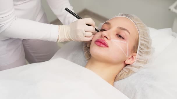 Cosmetoloog Maakt Markeringen Het Gezicht Van Patiënt Het Tekenen Van — Stockvideo