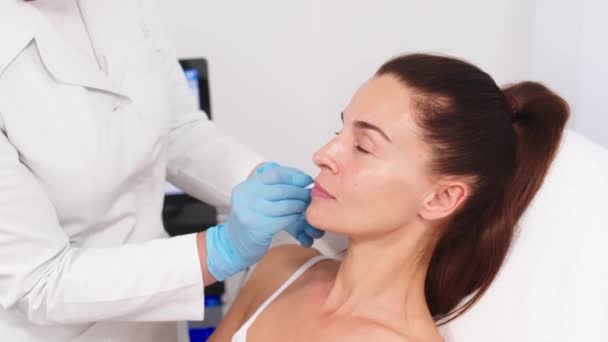 Läkare Kosmetolog Gör Ansiktsmarkeringar Till Mogna Medelålders Kvinna Innan Kosmetisk — Stockvideo