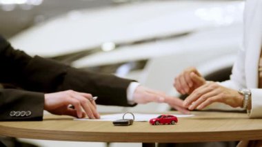 Araba satıcısı ve bir alıcının araba sigortası belgesi, kontrat ya da kira sözleşmesi imzalaması. Araba galerisinden yeni ya da kullanılmış araba almak ya da satmak.