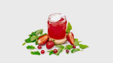 Çilek ve yapraklardan yapılmış taze meyve reçelli kavanoz.