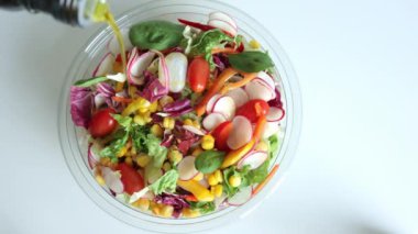 Şef sebze salatası pişiriyor. Salatalık, domates ve turpları karıştıran bir kadın. Sağlıklı beslenme alışkanlıkları, diyet, vejetaryen yemekleri.