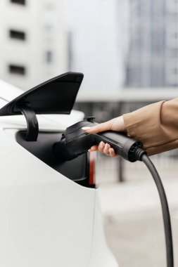 İstasyonda elinde elektrik prizi olan bir kadının elini kapat.