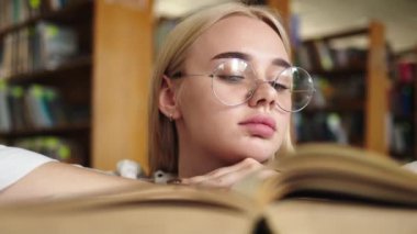 Elinde kitap olan genç bir kız öğrencinin yakın çekimi. Edebiyat tutkusu olan tatlı bir kız. Sınav hazırlığı, burs ve öğrenim hayatı kavramı.