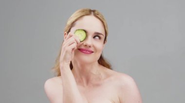 Mükemmel temiz ve sağlıklı bir cilde sahip mutlu bir kadın. Salatalık dilimlenmiş güzel bir kadın model..