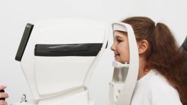 Yarık lamba kullanan çocuğun incelenmesi. Mikroskop ve odaklanmış ışık kaynağı. Merceğin durumunu belirlemek için gözün yüksek hassaslıkta incelenmesi için bir cihaz..