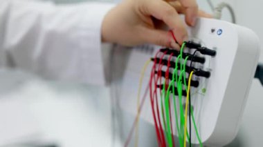 EEG sensörleri ile ilgilenen bir doktorun yakın çekimi, ileri tanı prosedürlerinde hassasiyet ve bakım. Modern tıp teknolojisi ve profesyonel uzmanlık sergilemek için ideal..