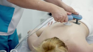 Fizyoterapist etkili ağrı kesici için TR-THERAPY tıbbi ekipmanı kullanıyor. Gelişmiş tedavi yöntemlerini ve modern fizyoterapi tekniklerini sergilemek için ideal..