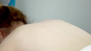 Genç bir kadının vücuduna masaj yapan masörün yakın çekimi. Sağlık ve kilo verme programı.        