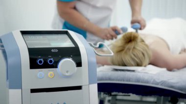 Fizyoterapist etkili ağrı kesici için TR-THERAPY tıbbi ekipmanı kullanıyor. Gelişmiş tedavi yöntemlerini ve modern fizyoterapi tekniklerini sergilemek için ideal..