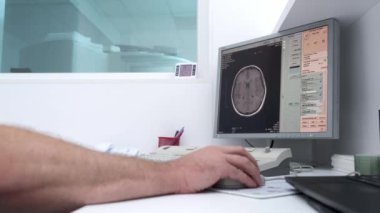 Radyoloji uzmanı beyin taraması sonuçlarını monitörde incelerken hasta MRI ya da CT taramasından geçiyor. Gelişmiş tıbbi tanı ve ekipman göstermek için ideal.
