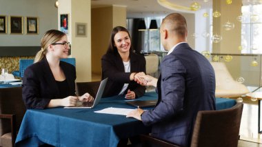 Modern bir çalışma ortamında çalışan bir grup insan, ekibin görev ve iş süreçlerini tartışıyor, iş kadını ve iş kadını, tokalaşıyor. Yönetici veya analitik koleksiyonu. 