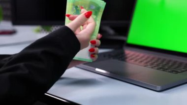 Yakın plan. Açık dizüstü bilgisayarı ve yığınla parası olan işyeri. Etkili para yönetimi. Evden çalış..     