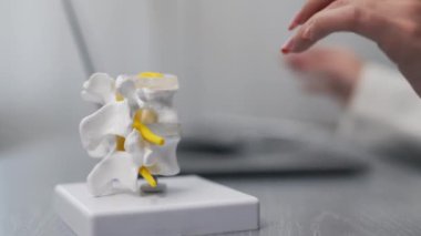 İnsan kemiklerinin yakın plan görüntüsü plastik model ve dizüstü bilgisayar ve MRI taramalarıyla çalışan doktor modern klinik, sağlık ve tıp konseptiyle sonuçlandı               