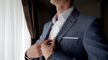 Takım elbiseli ve beyaz gömlekli genç bir adamın kırpılmış fotoğrafı. 