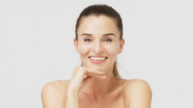 Gri arka planda poz veren güzel bir kadının portresi.                   