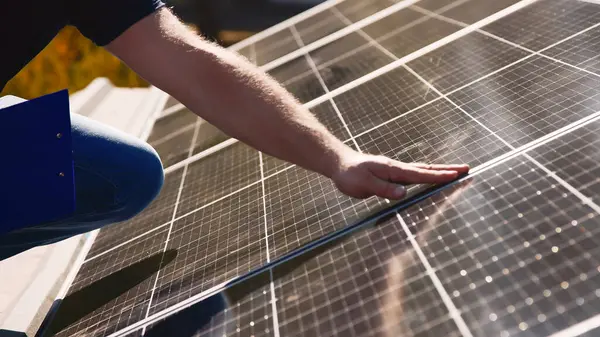 Güneş panellerini kalite ve istikrar için inceleyen teknisyen. Yenilenebilir enerji bakımı ve mühendislik hassasiyeti için mükemmel..