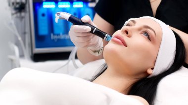 Kozmetik uzmanının cildini vakum makinesiyle cilalayıp temizleyişine yakın çekim. Cilt bakımı, gençleştirme ve kozmetoloji kavramı.