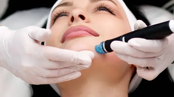 Kozmetik uzmanının cildini vakum makinesiyle cilalayıp temizleyişine yakın çekim. Cilt bakımı, gençleştirme ve kozmetoloji kavramı.