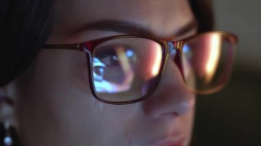 Gözlük takan, bilgisayarda kod yazan bir geliştiricinin yakın çekimi. Gözlüklerdeki kod ve analiz yansımaları siber güvenlik ve yazılım gelişimine odaklanmayı vurguluyor.