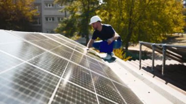 Güneş panellerini kalite ve istikrar için inceleyen teknisyen. Yenilenebilir enerji bakımı ve mühendislik hassasiyeti için mükemmel..