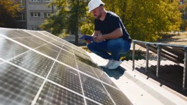 Güneş panellerini kalite ve istikrar için inceleyen teknisyen. Yenilenebilir enerji bakımı ve mühendislik hassasiyeti için mükemmel..