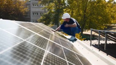 Güneş panellerini kalite ve istikrar için inceleyen teknisyen. Yenilenebilir enerji bakımı ve mühendislik hassasiyeti için mükemmel..