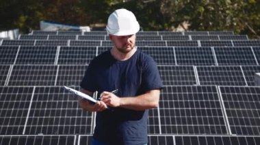 Güneş panellerini kalite ve istikrar için inceleyen teknisyen. Yenilenebilir enerji bakımı ve mühendislik hassasiyeti için mükemmel..