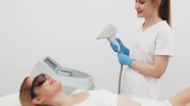 Zarif bir kozmetoloji kliniğinde gelişmiş ekipmanlarla lazer temizliğinden geçen genç bir kadın. Profesyonel vücut bakımı deneyimi 