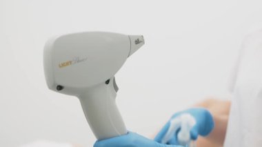 Güzellik uzmanı lazer tüyü temizlemeye hazırlanıyor. Modern bir klinikte profesyonel cilt bakımının ve güzellik tedavisinin aydınlatılması için ideal..