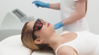 Güzellik uzmanı lazer tüyü temizlemeye hazırlanıyor. Modern bir klinikte profesyonel cilt bakımının ve güzellik tedavisinin aydınlatılması için ideal..