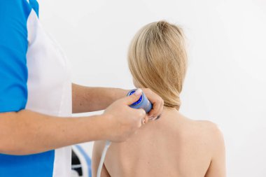 Fizyoterapist genç bir kadına şok dalgası terapisi uyguluyor. İyileşmeyi teşvik eden ve acıyı azaltan zararsız bir tedavi. Modern fizyoterapi tekniklerini ve tedavi yöntemlerini sergilemek için ideal..          