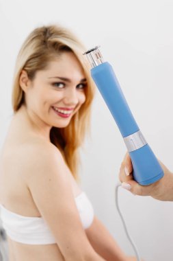 Fizyoterapist genç bir kadına şok dalgası terapisi uyguluyor. İyileşmeyi teşvik eden ve acıyı azaltan zararsız bir tedavi. Modern fizyoterapi tekniklerini ve tedavi yöntemlerini sergilemek için ideal..          