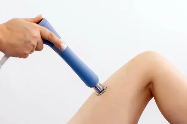 Fizyoterapist genç bir kadına şok dalgası terapisi uyguluyor. İyileşmeyi teşvik eden ve acıyı azaltan zararsız bir tedavi. Modern fizyoterapi tekniklerini ve tedavi yöntemlerini sergilemek için ideal..          