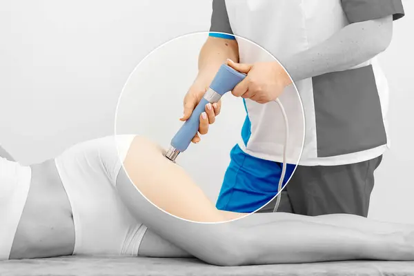 stock image Physiotherapist provides shockwave therapy to young woman. Non-invasive treatment that promotes healing and reduces pain. Ideal for showcasing modern physiotherapy techniques and recovery methods.          