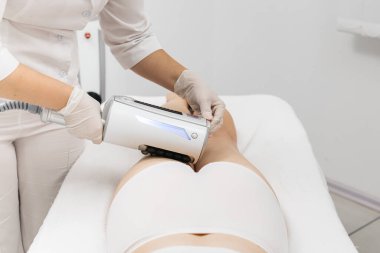 Derin selülit azaltımı ve vücut hatları için endosphere terapisi. Bir terapist cihazı modern bir klinikte uyguluyor, cilt yenilenmesini arttırıyor..