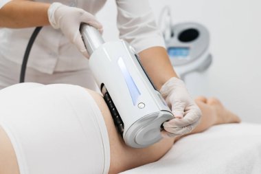 Derin selülit azaltımı ve vücut hatları için endosphere terapisi. Bir terapist cihazı modern bir klinikte uyguluyor, cilt yenilenmesini arttırıyor..