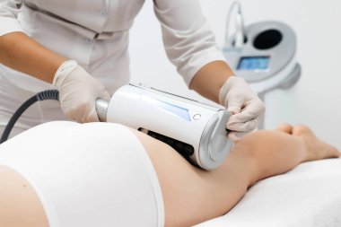 Derin selülit azaltımı ve vücut hatları için endosphere terapisi. Bir terapist cihazı modern bir klinikte uyguluyor, cilt yenilenmesini arttırıyor..