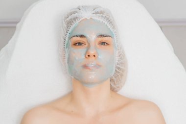 Modern salonda aljinat maskeli genç bir kadın..        