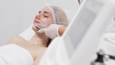 Kozmetik uzmanı yüz gençleştirme ve sıkma için RF kaldırma ameliyatı yapıyor. Bu müdahale etmeyen prosedür cildinizi sertleştirir ve pürüzsüzleştirir. Güzellik rutininizi geliştirir..