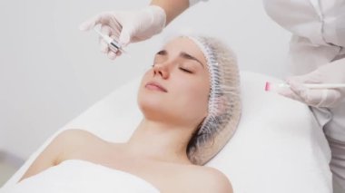 Kozmetik uzmanı modern bir güzellik kliniğinde gelişmiş cilt bakımı tekniklerini vurgulayan bir yüz kremi uyguluyor. Reklamınızda birinci sınıf spa tedavilerini sergilemek için ideal..     