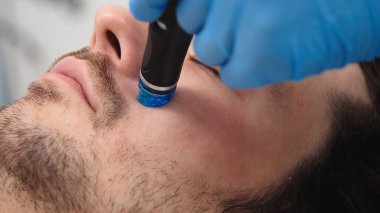 Adam güzellik kliniğinde yüz bakımı görüyor. Bu gelişmiş prosedür cildinizi gençleştirir ve canlandırır. Reklamlarınızda kaliteli cilt bakımı için idealdir..