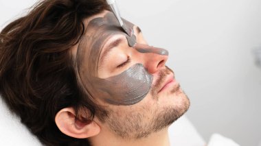 Yakışıklı bir adam güzellik uzmanından gençleştirici bir maske alır. Reklamınızda cilt gerdirme ve gelişmiş cilt bakımı. Profesyonel yüz bakımı için mükemmel..