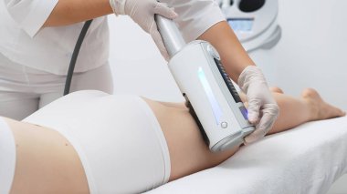 Derin selülit azaltımı ve vücut hatları için endosphere terapisi. Bir terapist cihazı modern bir klinikte uyguluyor, cilt yenilenmesini arttırıyor..