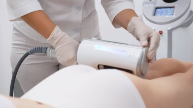 Derin selülit azaltımı ve vücut hatları için endosphere terapisi. Bir terapist cihazı modern bir klinikte uyguluyor, cilt yenilenmesini arttırıyor..