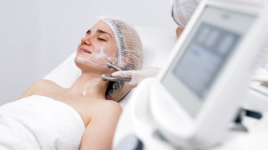 Kozmetik uzmanı yüz gençleştirme ve sıkma için RF kaldırma ameliyatı yapıyor. Bu müdahale etmeyen prosedür cildinizi sertleştirir ve pürüzsüzleştirir. Güzellik rutininizi geliştirir..