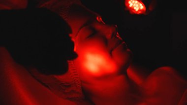 Kozmetik uzmanı yüz gençleştirme için LED ışık terapisi uyguluyor.. 