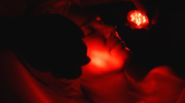 Kozmetik uzmanı yüz gençleştirme için LED ışık terapisi uyguluyor.. 