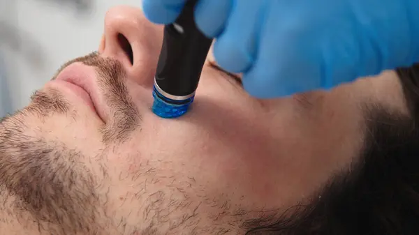 Adam güzellik kliniğinde yüz bakımı görüyor. Bu gelişmiş prosedür cildinizi gençleştirir ve canlandırır. Reklamlarınızda kaliteli cilt bakımı için idealdir..