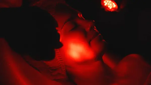 Kozmetik uzmanı yüz gençleştirme için LED ışık terapisi uyguluyor.. 